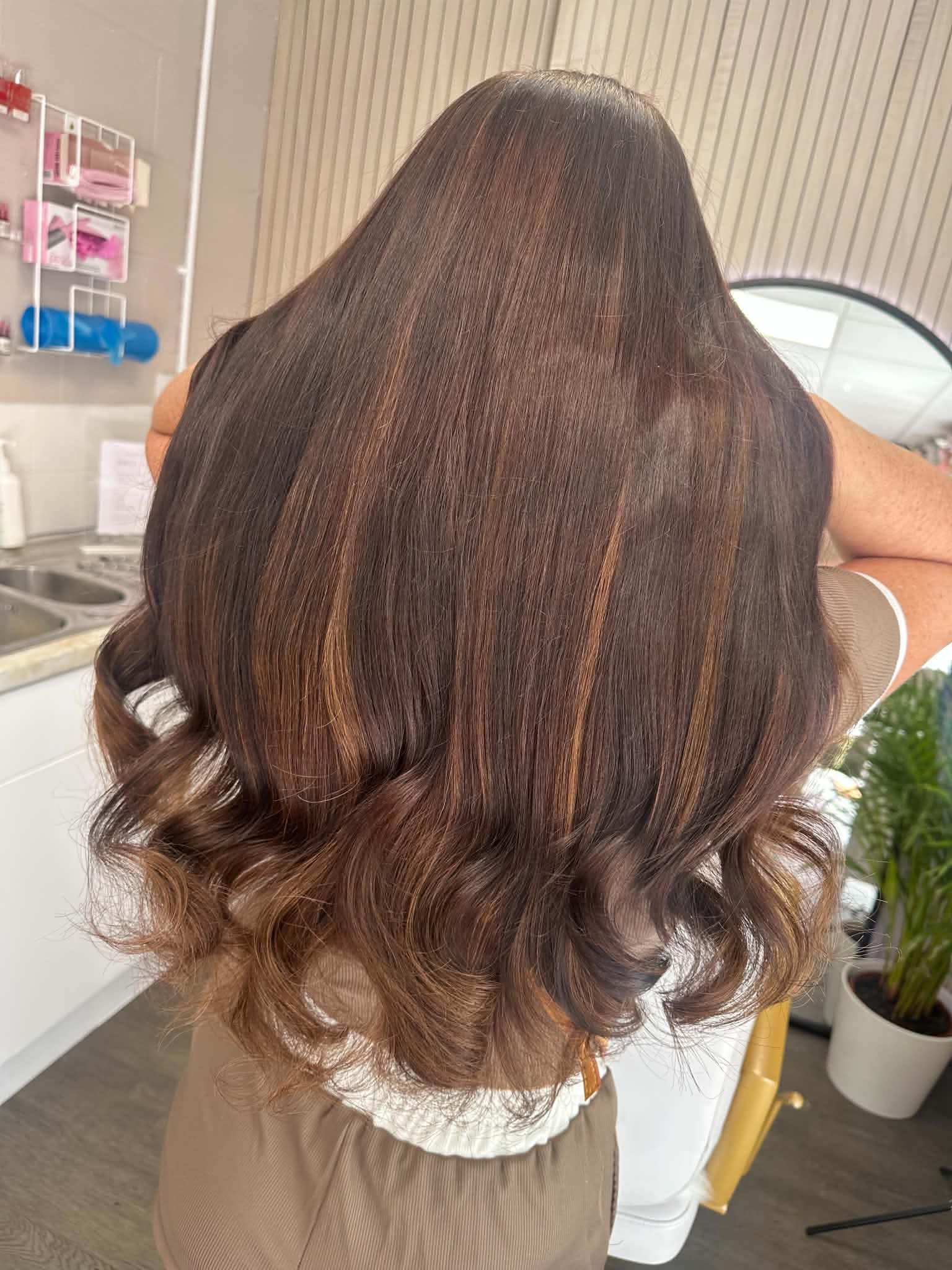 Rich brunette hair transformation with polished curls.