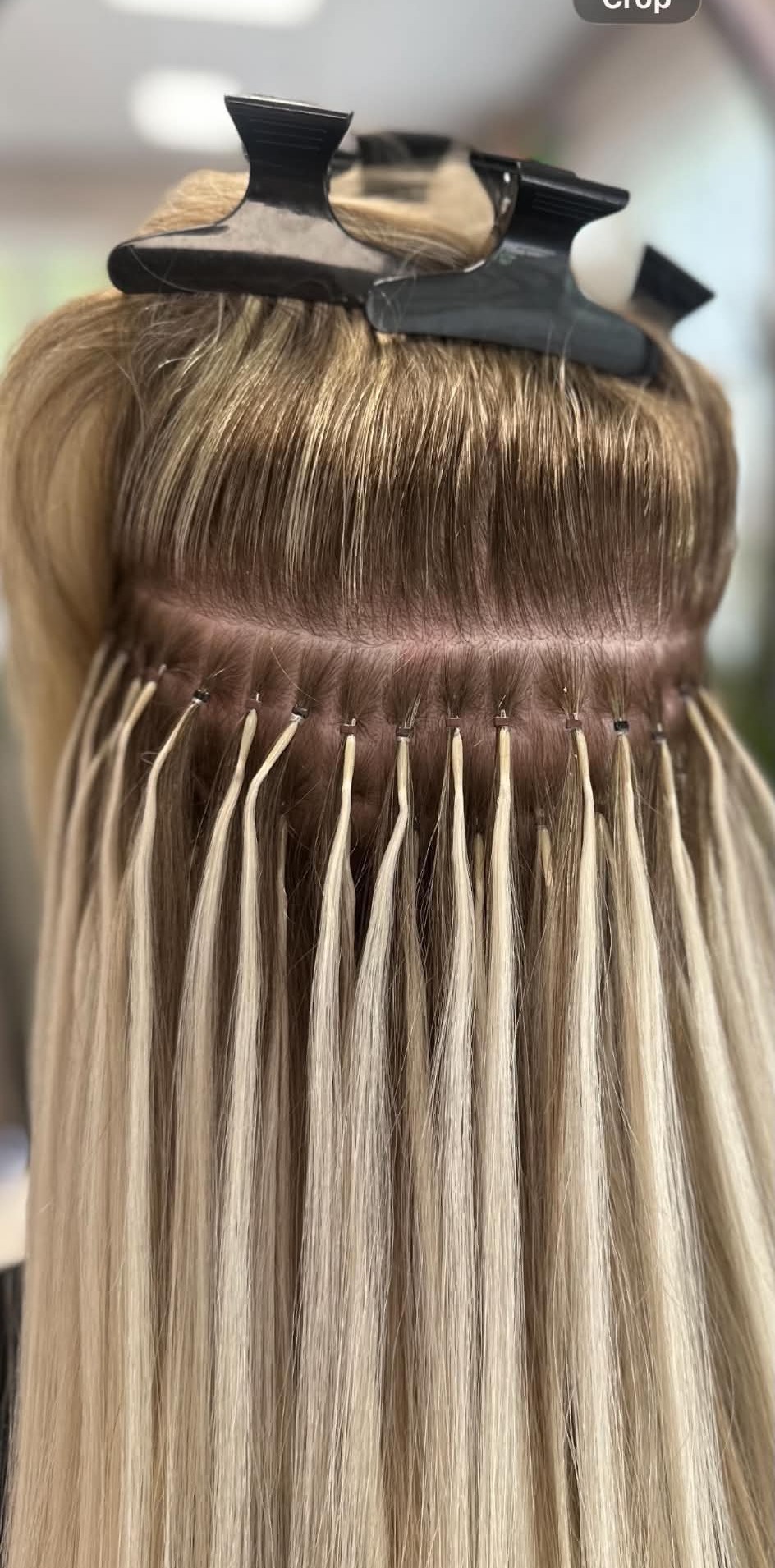 Close-up detail of a hair extension fitting process.