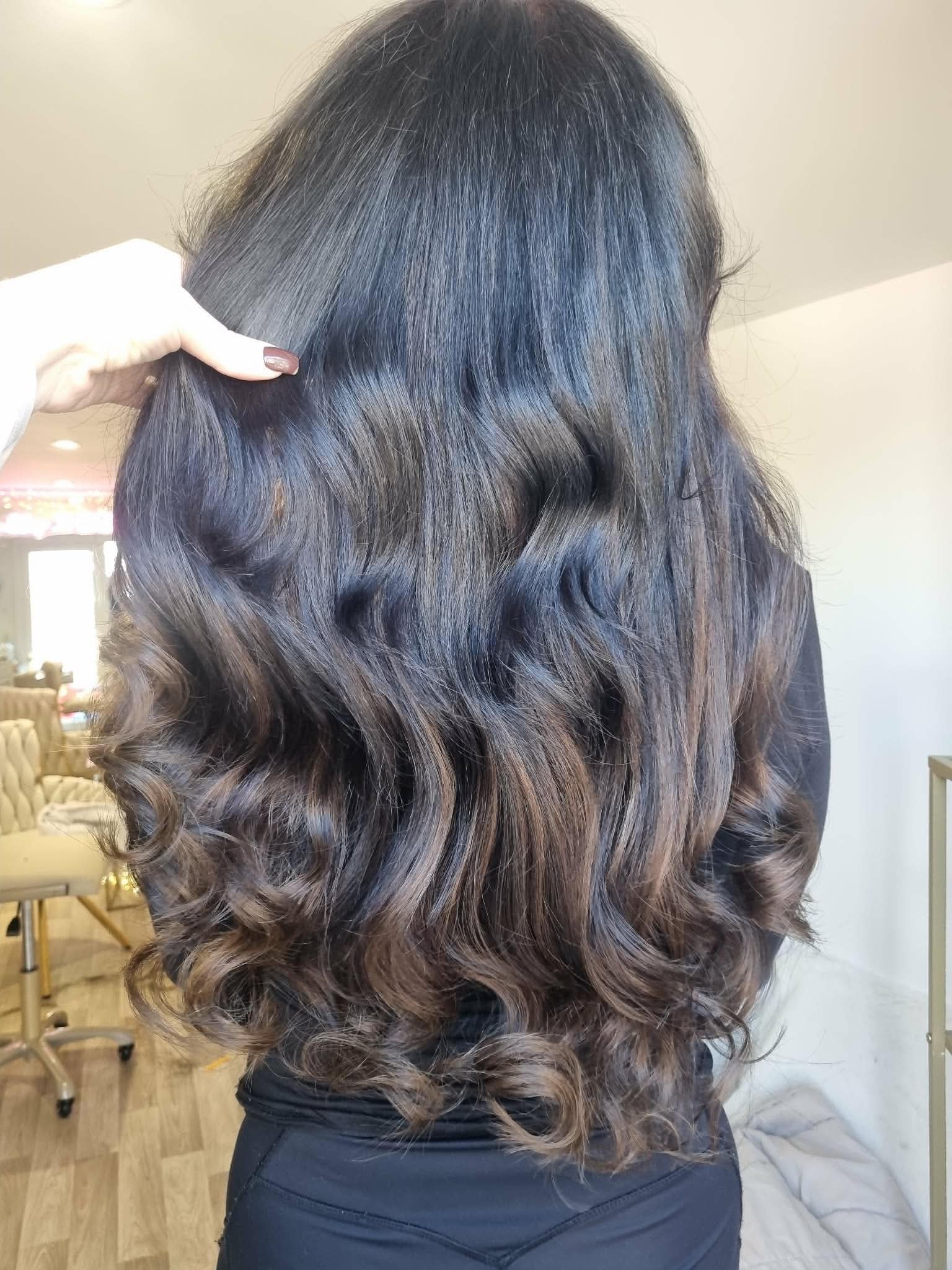 Dark brunette hair extensions finished in luxury waves.