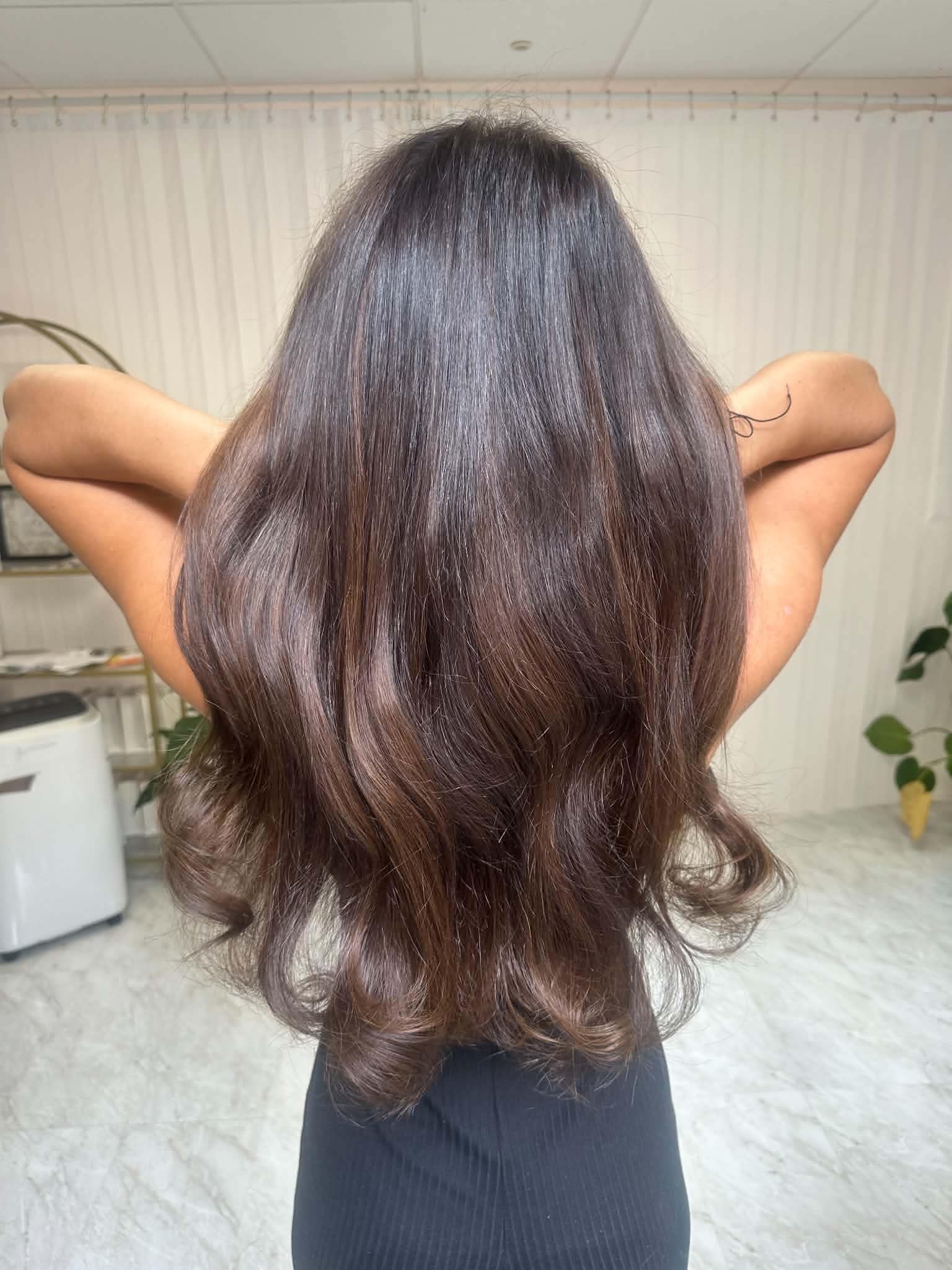 Smooth brunette hair extensions with a soft curled finish.