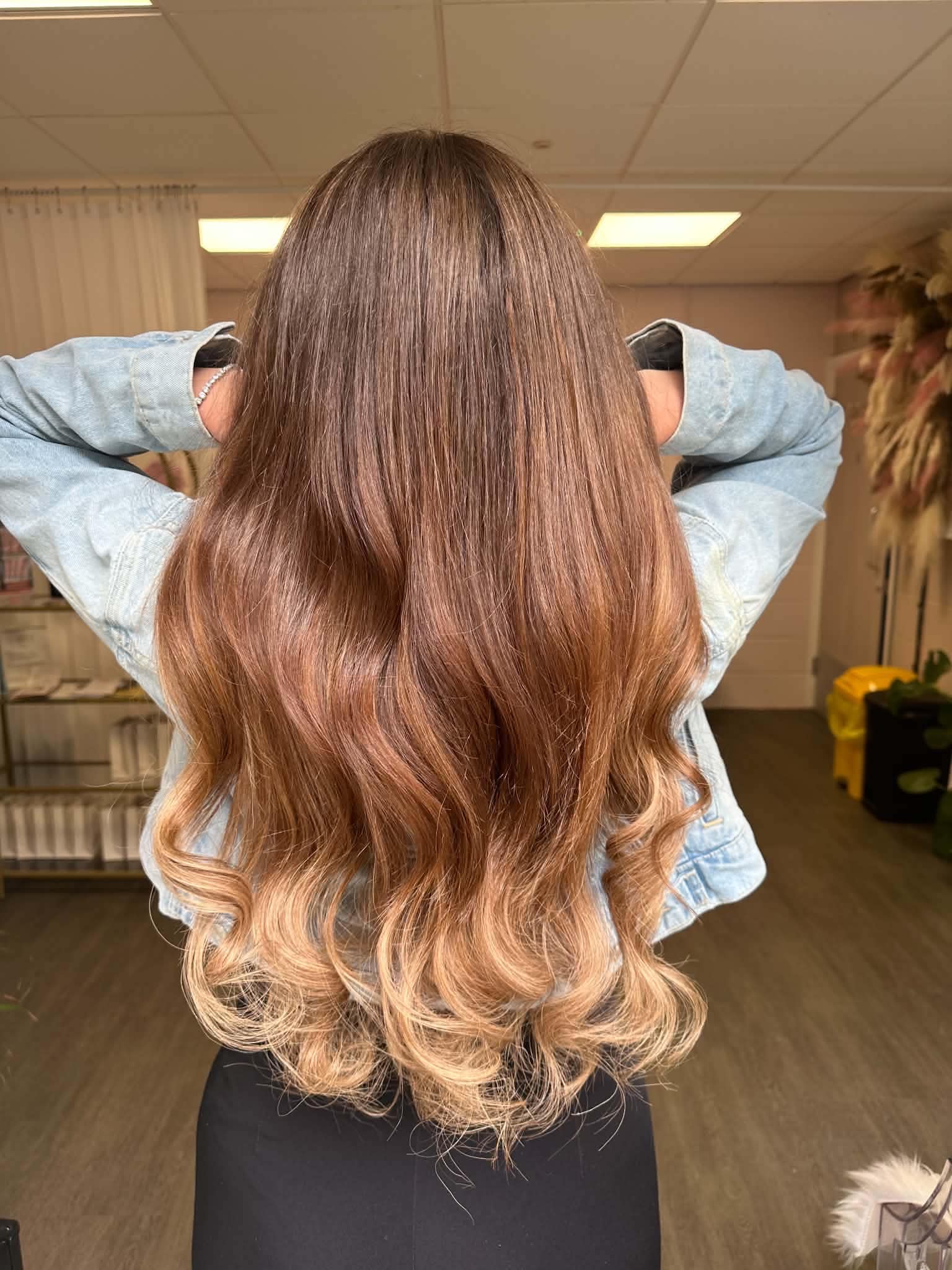 Brunette to blonde ombré hair extension result with volume and shine.